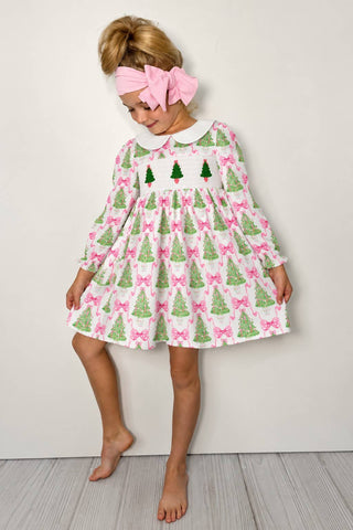 A sleeveless pink gingham dress with smocking and embroidery, featuring a crew neckline and above-the-knee length.