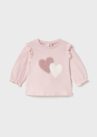 Pink baby top with heart designs on a light gray background