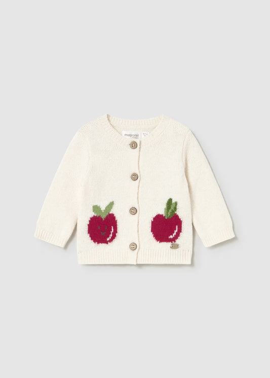 White cardigan with red apple designs on a light gray background