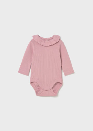 Pink ribbed baby bodysuit with a ruffled collar on a light gray background